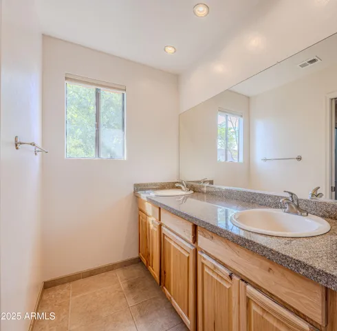 a bathroom with a granite countertop sink a mirror and a window