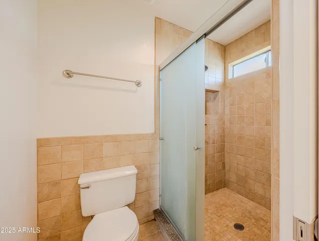 a bathroom with a toilet and a shower