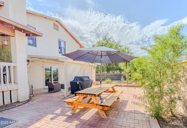 a view of patio with chairs and table under an umbrella