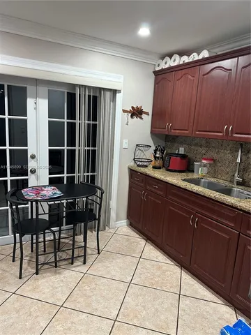 a kitchen with granite countertop wooden cabinets and a stove top oven