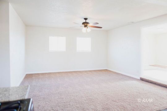 148 South Sunset Street Ridgecrest, CA 93555 - Photo 10 of 25 an empty room with windows and ceiling fan