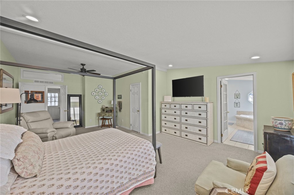 23301 Ridge Rte Drive, Unit 246 Laguna Hills, CA 92653 - Photo 18 of 35 a spacious bedroom with a bed a couch and a flat screen tv