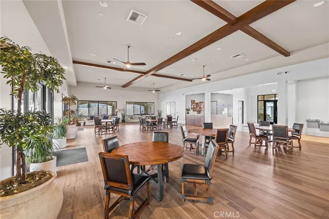 a dining room with furniture potted plants and wooden floor