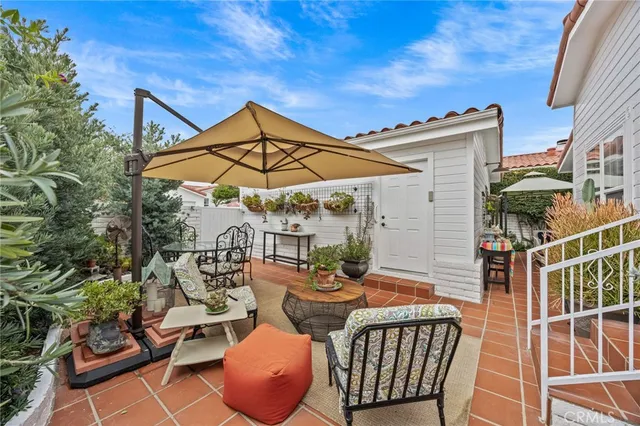 a view of a patio with couches table and chairs and potted plants
