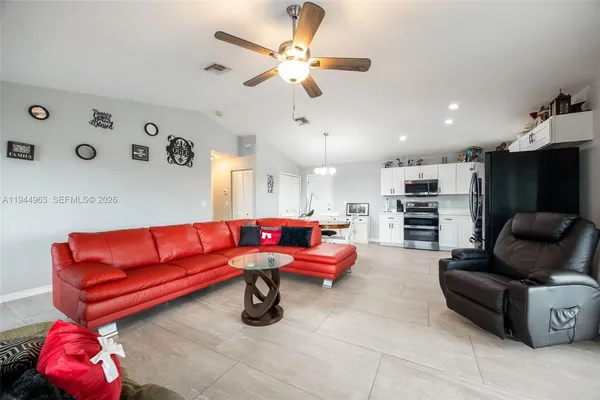 a living room with furniture and kitchen view