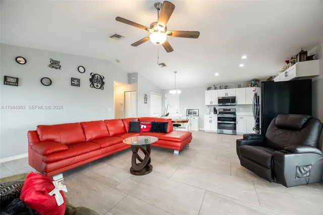 a living room with furniture and kitchen view