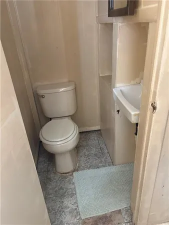 a white toilet sitting next to a white sink and vanity