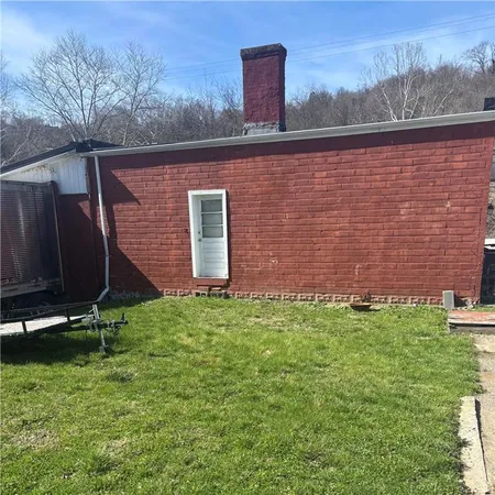 a view of a backyard with plants and a bench