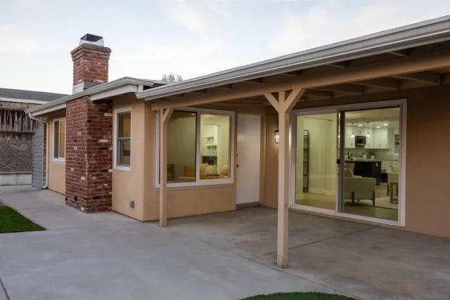 a view of a house with a backyard and a patio