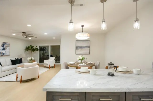 a living room with kitchen island furniture and a chandelier