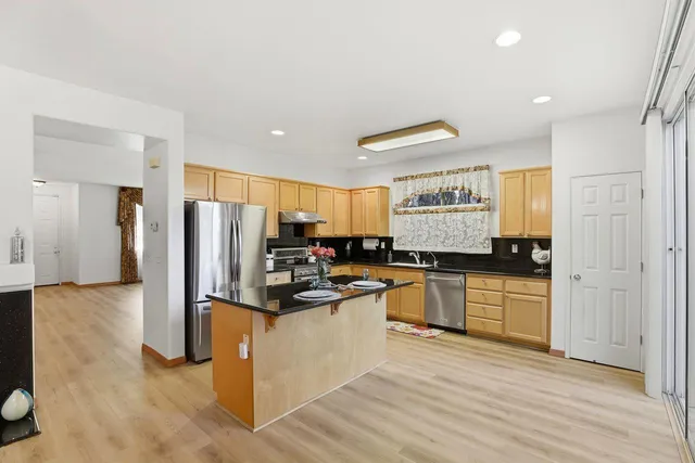 a kitchen with stainless steel appliances granite countertop a stove a refrigerator and a microwave