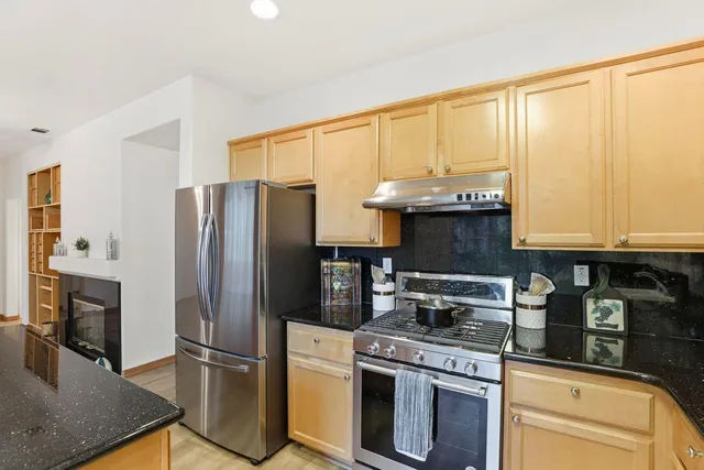 a kitchen with stainless steel appliances granite countertop a sink stove and cabinets