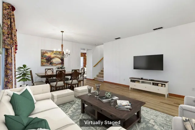 a living room with furniture a flat screen tv and a window