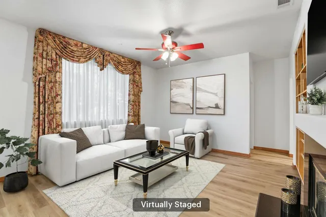 a living room with furniture a flat screen tv and a window