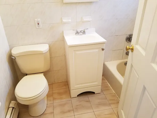 a white toilet sitting next to a white sink and vanity