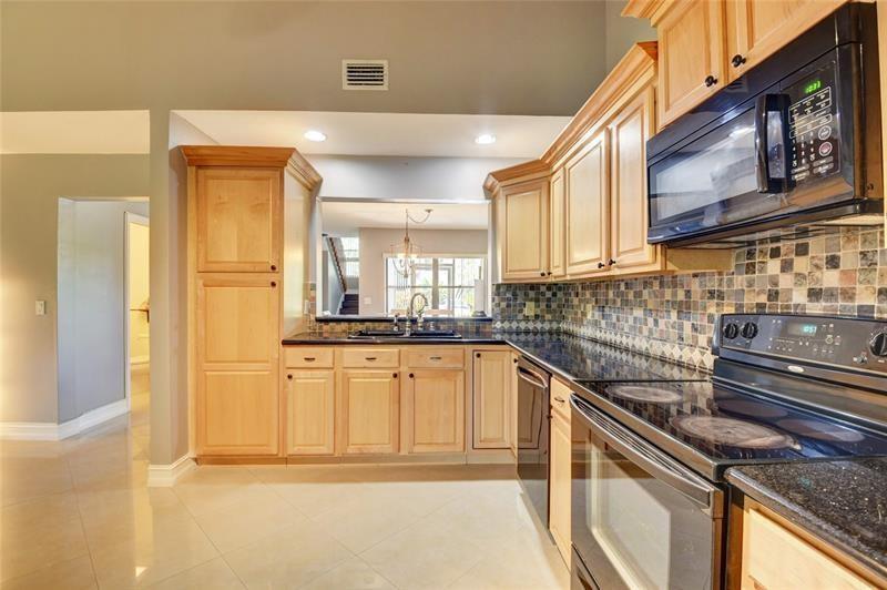 9316 Ketay Circle Boca Raton, FL 33428 - Photo 3 of 30 a kitchen with stainless steel appliances granite countertop a sink and cabinets