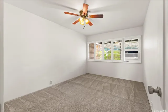 an empty room with windows and chandelier fan