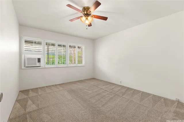 an empty room with windows and a ceiling fan