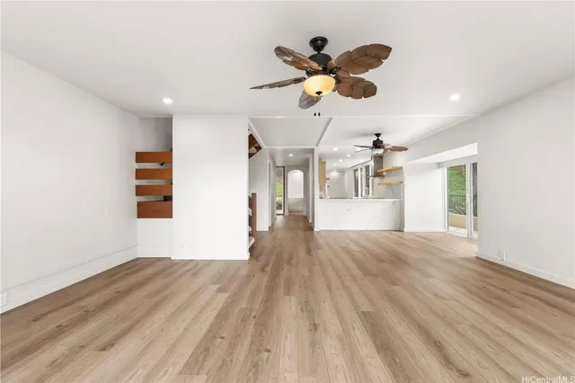 a view of a room with wooden floor and ceiling fan