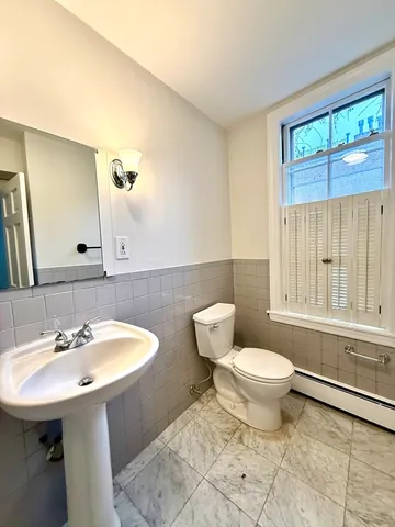 a bathroom with a sink a toilet and a mirror