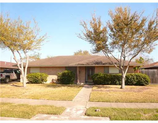 a front view of a house with a yard and trees