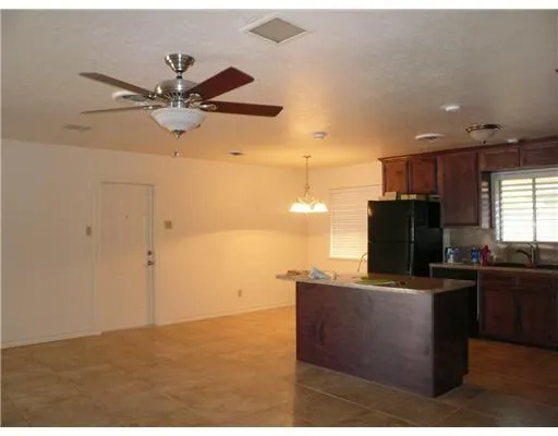 a kitchen with kitchen island a refrigerator stove and a sink