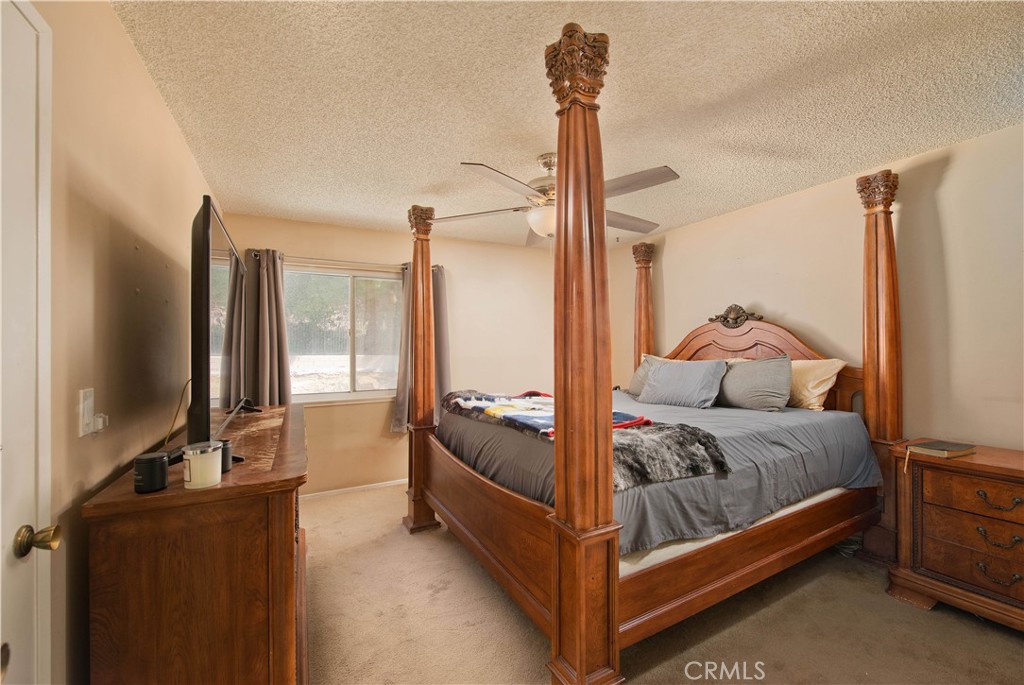 29262 Florabunda Road Canyon Country, CA 91387 - Photo 12 of 27 a bedroom with a bed and large flat tv screen