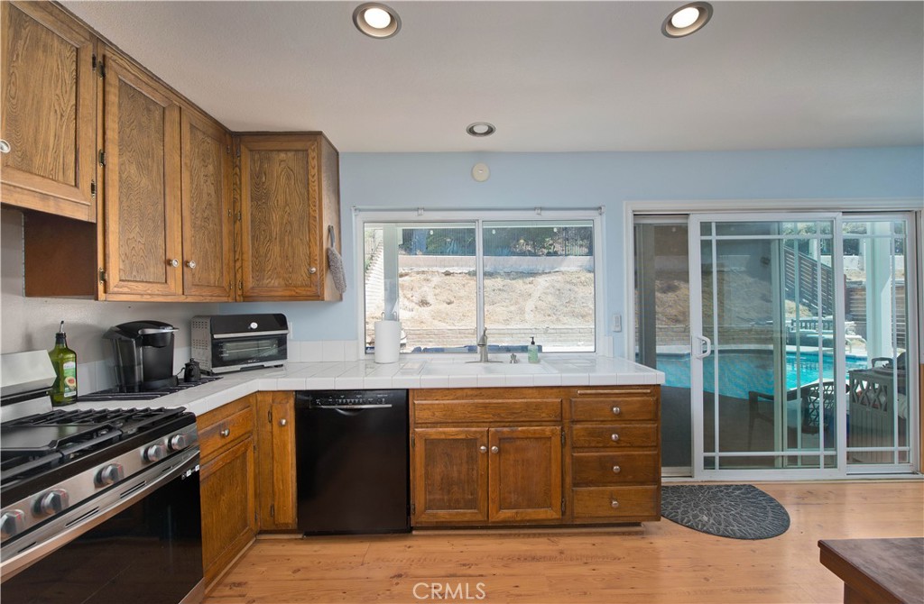 29262 Florabunda Road Canyon Country, CA 91387 - Photo 7 of 27 a kitchen with a stove a sink and a microwave