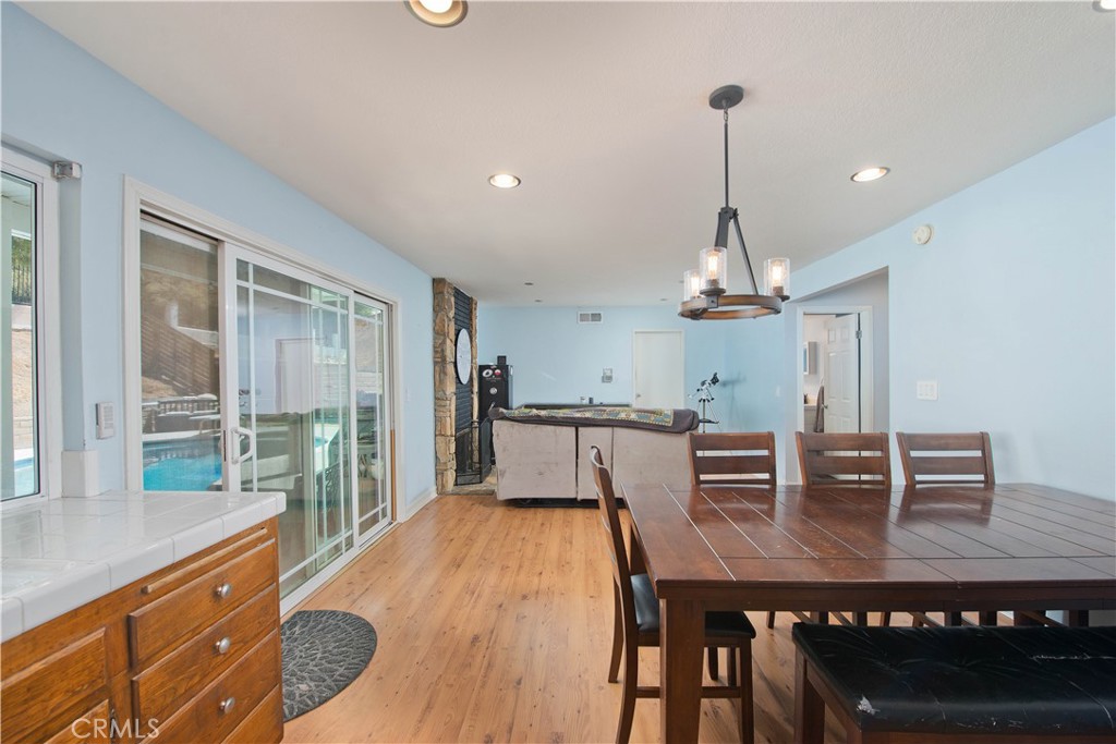 29262 Florabunda Road Canyon Country, CA 91387 - Photo 9 of 27 a dining room with furniture a chandelier and wooden floor