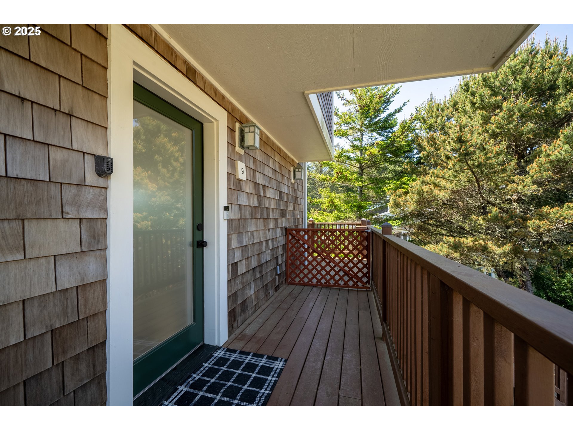 505 Capes Drive, Unit 9 Oceanside, OR 97141 - Photo 26 of 45 a balcony with wooden floor and yard in back