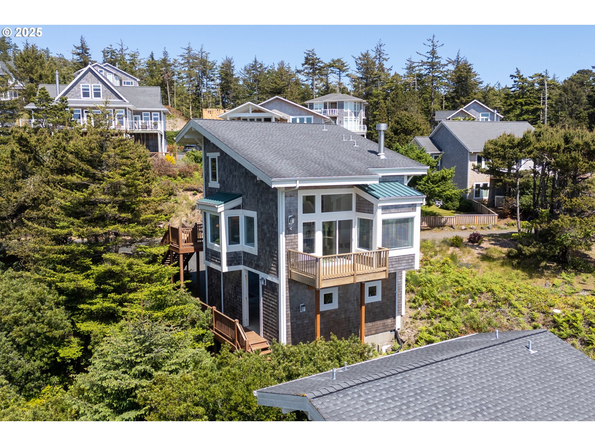 505 Capes Drive, Unit 9 Oceanside, OR 97141 - Photo 27 of 45 a aerial view of a house next to a yard