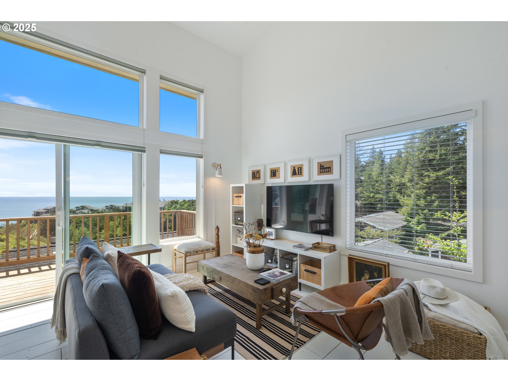 505 Capes Drive, Unit 9 Oceanside, OR 97141 - Photo 3 of 45 a living room with furniture a flat screen tv and a floor to ceiling window