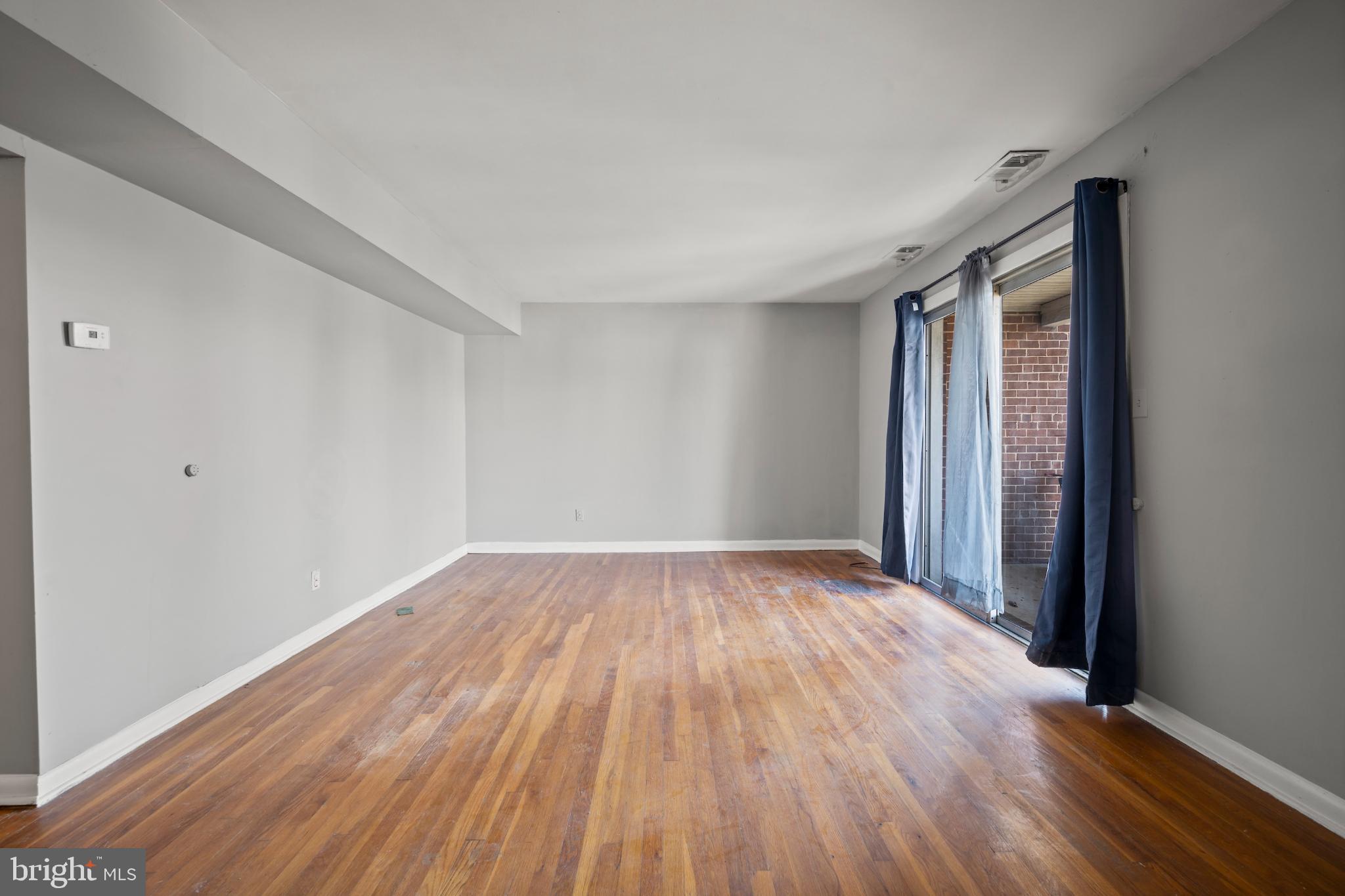 6511 Parsons Avenue Baltimore, MD 21215 - Photo 11 of 25 a view of an empty room with wooden floor and a window