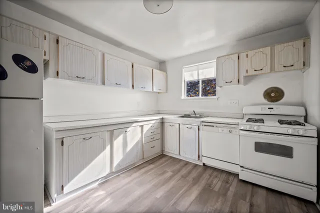 a kitchen with kitchen island white cabinets and white appliances