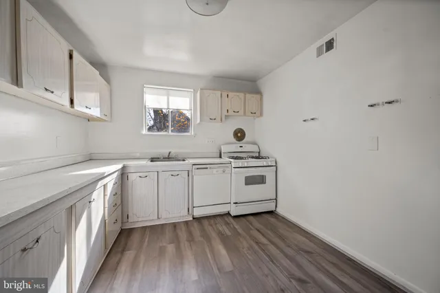 a kitchen with sink a stove and cabinets