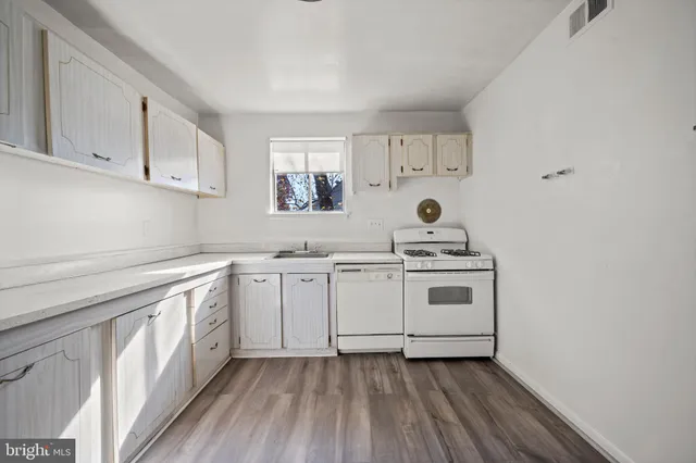 a kitchen with a stove cabinets and a sink
