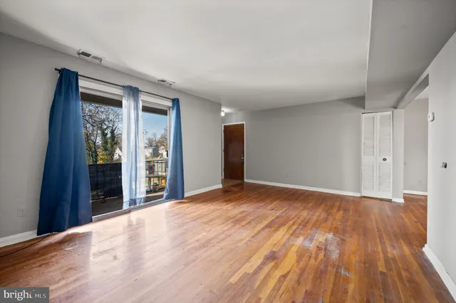a view of an empty room with wooden floor