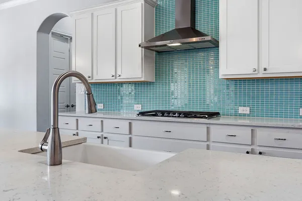 a kitchen with granite countertop white cabinets and a stove