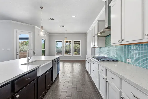 a large kitchen with granite countertop lots of counter space sink and a large window