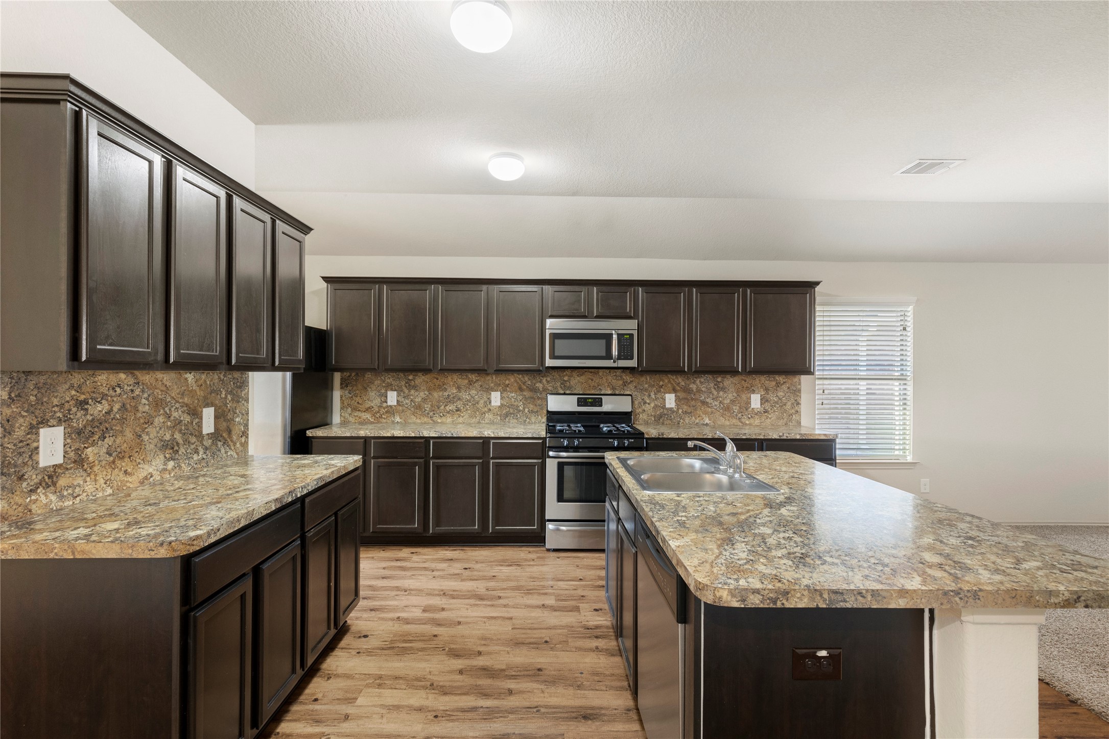 24407 Pigeon Berry Drive Spring, TX 77373 - Photo 10 of 34 a kitchen with stainless steel appliances granite countertop a sink stove and cabinets