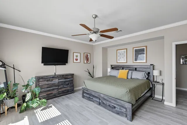 a bedroom with a bed flat screen tv and a potted plant