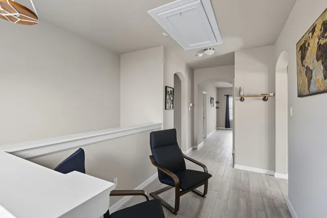 a view of a hallway to a livingroom with furniture and wooden floor