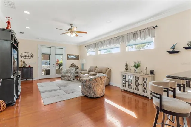 a living room with furniture a chandelier and a flat screen tv