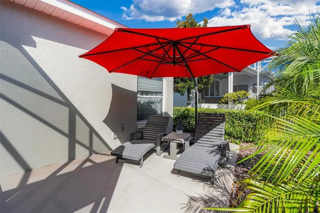 a view of patio with chairs and table under an umbrella