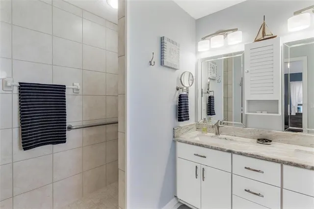 a bathroom with a granite countertop sink and a mirror