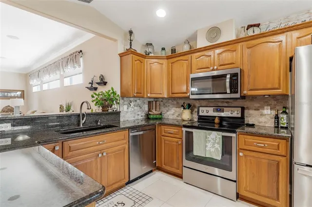 a kitchen with stainless steel appliances granite countertop a sink stove and microwave