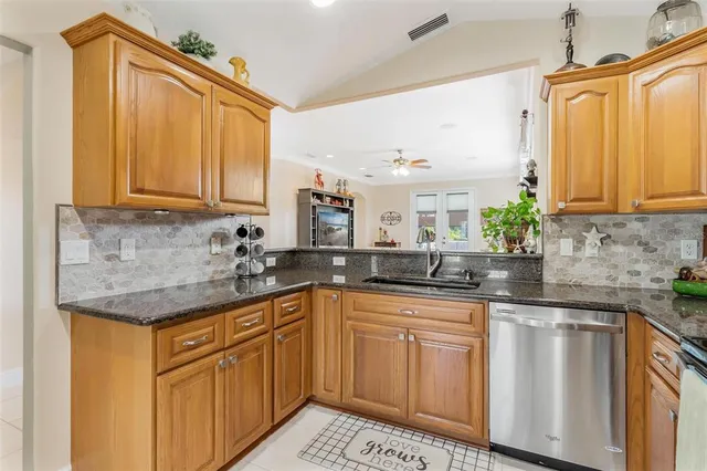 a kitchen with stainless steel appliances granite countertop a sink a stove and cabinets
