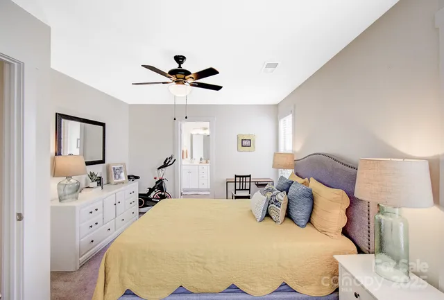 a spacious bedroom with a bed and a chandelier