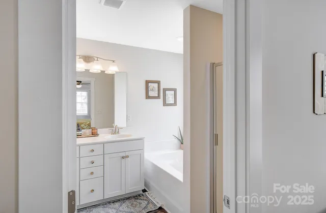 a en suite bathroom with a double vanity sink a mirror and a