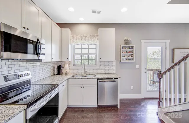 a kitchen with stainless steel appliances a sink stove and cabinets